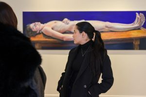 Estudiante observa una pintura colorida de una figura recostada en Lyndsey Ingram.