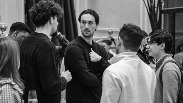 Black and white photograph of a group of students talking and gesturing during an ESE Madrid campus gathering.