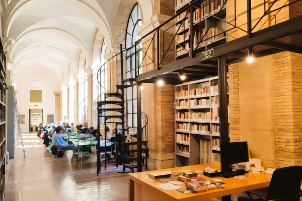 Students studying in a bright reading room with bookshelves and workspaces in Rome’s historic center near the ESE Campus.