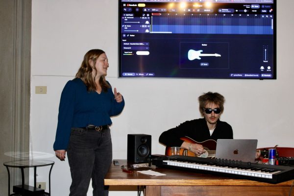 Studentessa di ESE Firenze durante un workshop di musica guidato da studenti con chitarra e software audio.