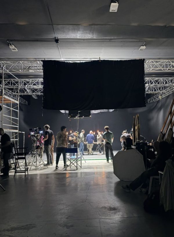 Film crew and equipment working inside a professional studio during a shoot.
